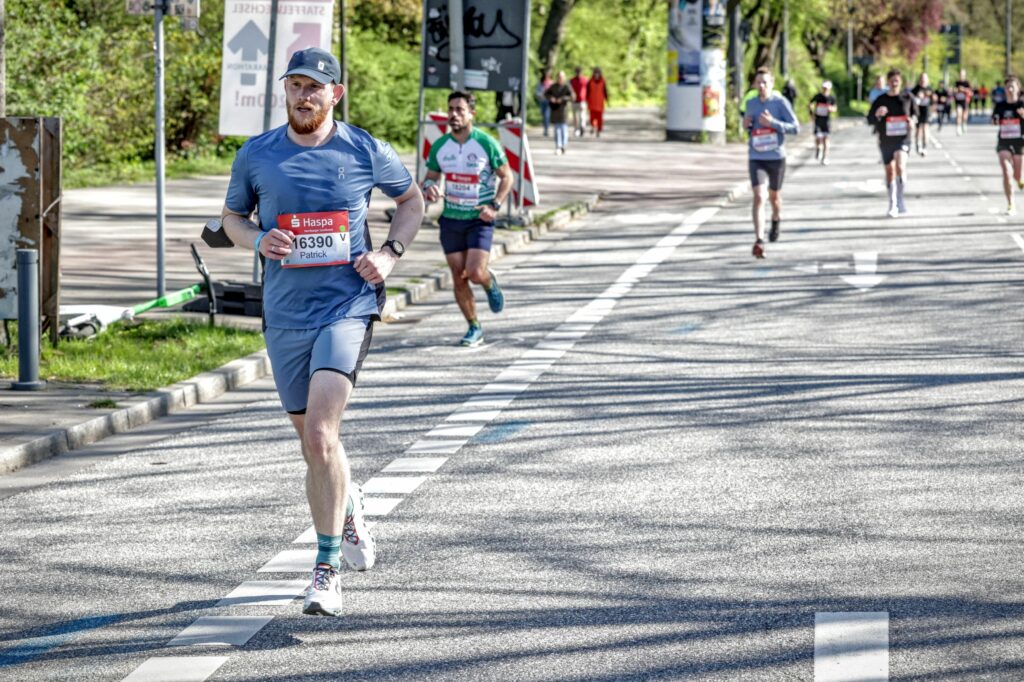 Läufer auf Marathonstrecke mit angestrengtem Gesicht - ENDSPURT Podcast